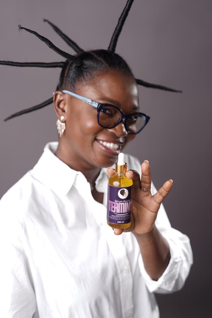 Femme souriante tenant un flacon de sérum TERMINUS